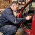 Mécanicien effectuant la remise à zéro du voyant vidange sur une Renault Clio 2 dans un garage